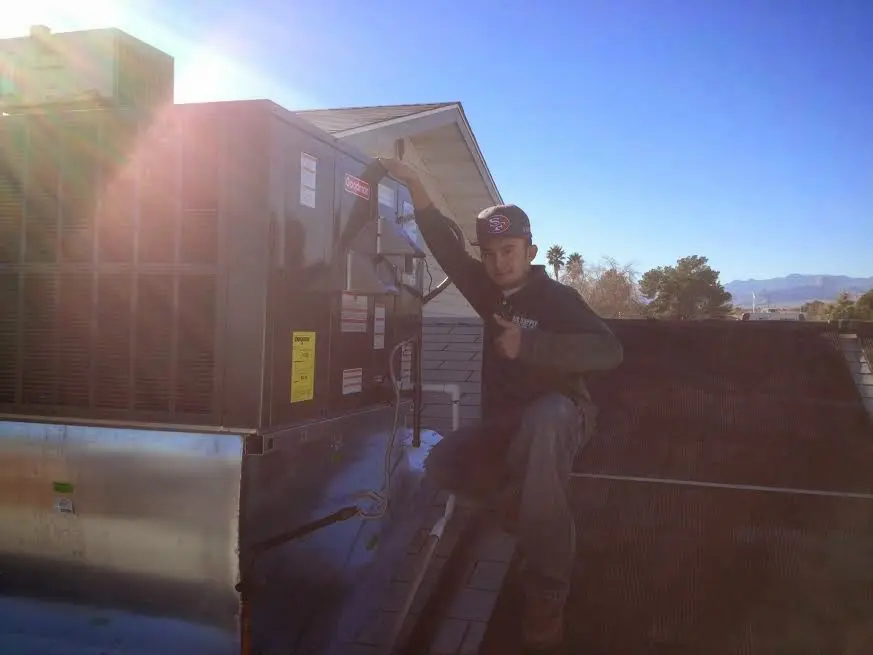 HVAC technician performing AC Tune-Up on a rooftop unit in Norristown