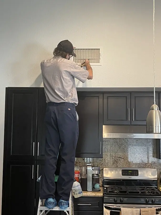 Technician inspecting an air vent during HVAC service in Norristown